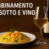 Abbinamento vino e risotto allo zafferano con gamberi e zucchine. Un bicchiere di vino bianco e una bottiglia completano la scena.