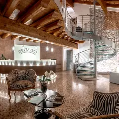 Interno di una cantina con reception, scala a chiocciola e esposizione di bottiglie. Ideale per cantine da visitare Valdobbiadene.