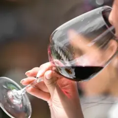 Donna assapora un vino amabile, con un sorso che promette piacere.