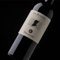 Bottiglia di vino rosso "Le Stanze del Poliziano" su sfondo nero. L'etichetta presenta un profilo silhouette e testo calligrafico.