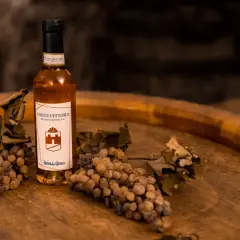 Bottiglia di Recioto di Soave con uva appassita e foglie secche, suggerendo i suoi abbinamenti.