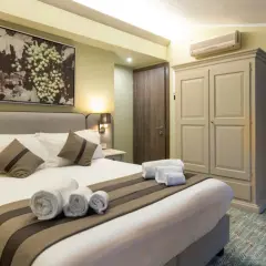 Camera accogliente con letto comodo, quadro di uva e un invito a dormire in cantina a Valpolicella.