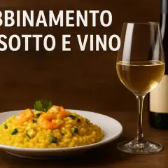 Abbinamento vino e risotto allo zafferano con gamberi e zucchine. Un bicchiere di vino bianco e una bottiglia completano la scena.