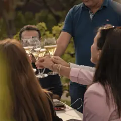 Un brindisi al festival della Franciacorta, con amici che alzano i calici di bollicine dorate in un'atmosfera di festa.