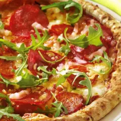 Pizza con salame piccante, rucola e formaggio filante. Un abbinamento classico e gustoso per un'esperienza culinaria indimenticabile.
