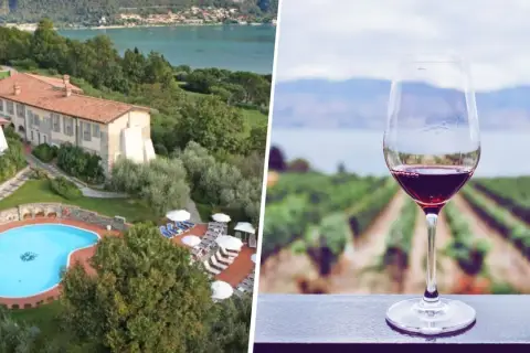 Un bicchiere di vino rosso con vigneti e lago sullo sfondo, ideale per una visita cantine Franciacorta con pernottamento.