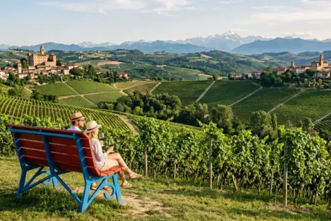 Coppia su una panchina ammira il panorama delle Langhe, un perfetto tour enogastronomico tra vigneti e borghi storici.