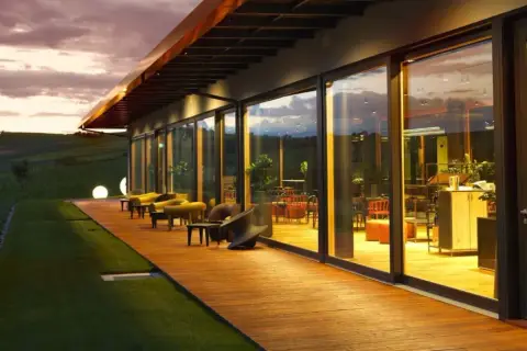 Un perfetto aperitivo nel Monferrato con vista sui vigneti al tramonto. Tavolini e comode sedute sulla terrazza in legno.