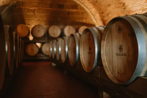 Cantina con botti di legno invecchiate, pronte per il vino. Il tempo passa, ma il vino scade solo se non curato.