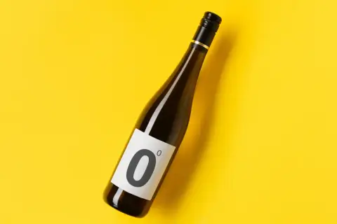 Bottiglia di vino dealcolato con etichetta "0°" su sfondo giallo.