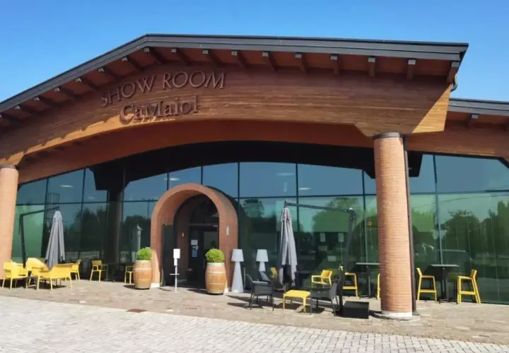 Show Room Ca' Maiol, un'elegante cantina con ampie vetrate e arredi esterni invitanti.