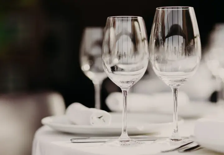 Due calici d'acqua e vino, pronti per una cena. Le differenze tra i calici sono sottili, ma importanti per l'esperienza.