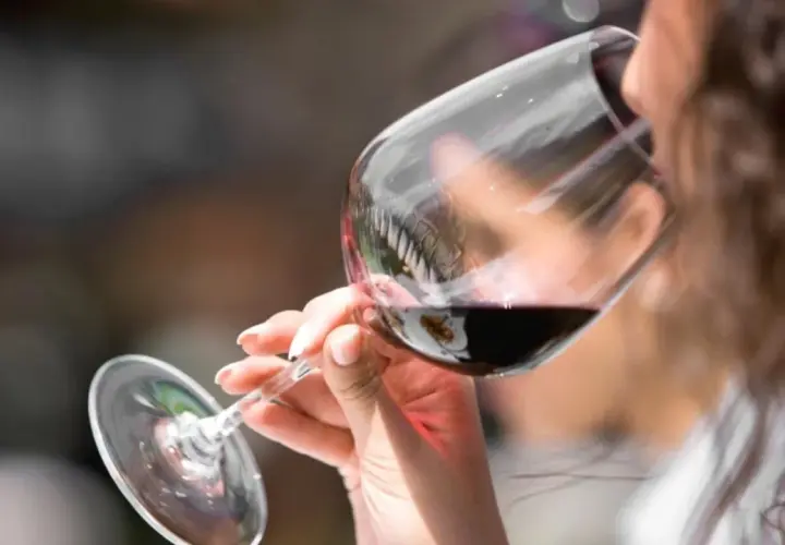 Donna assapora un vino amabile, con un sorso che promette piacere.