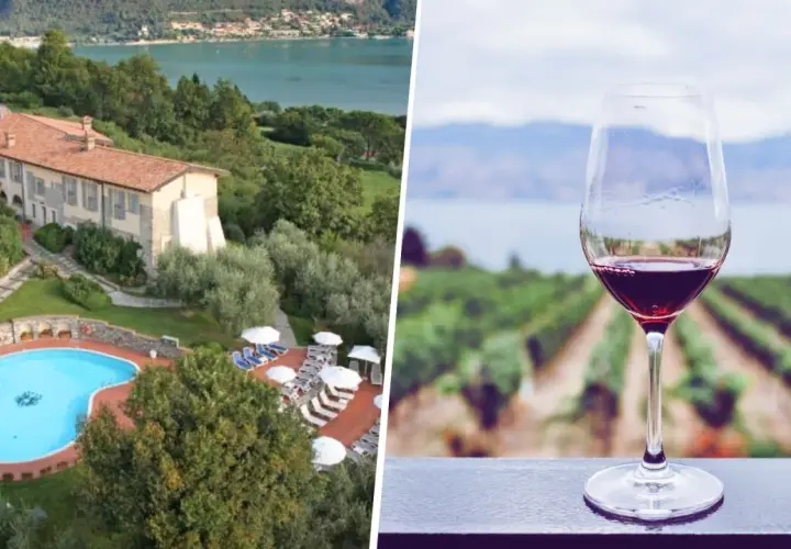Un bicchiere di vino rosso con vigneti e lago sullo sfondo, ideale per una visita cantine Franciacorta con pernottamento.