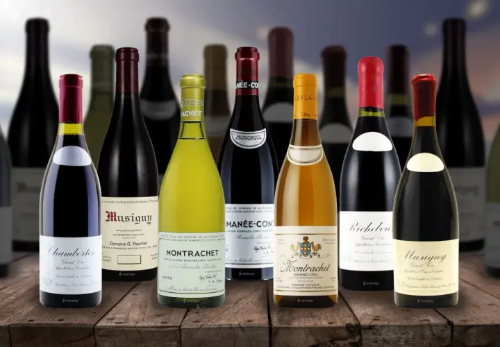 Una selezione di bottiglie costose di vino pregiato, tra cui Montrachet e Musigny, disposte su un tavolo di legno.