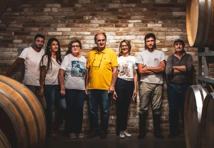 La famiglia al completo di Ca del Bric, in posa tra botti di legno e mattoni antichi, pronta a condividere la passione per il vino.