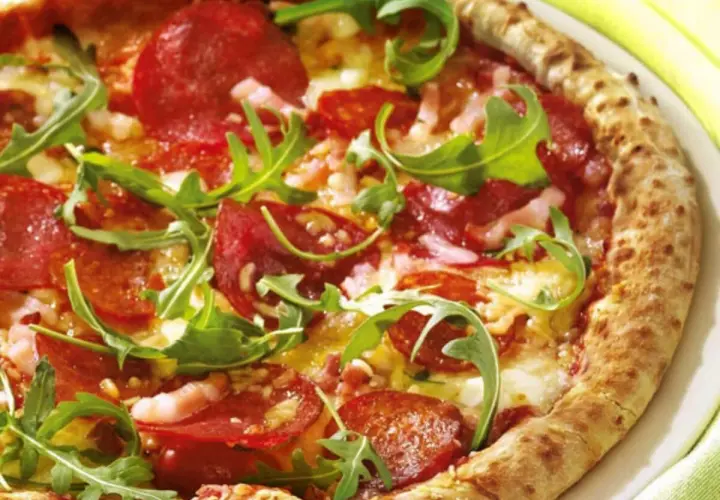 Pizza con salame piccante, rucola e formaggio filante. Un abbinamento classico e gustoso per un'esperienza culinaria indimenticabile.