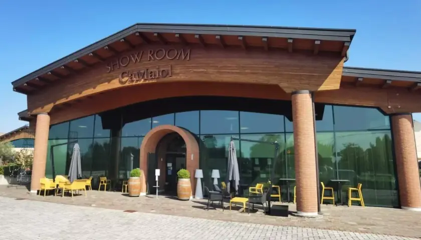 Show Room Ca' Maiol, un'elegante cantina con ampie vetrate e arredi esterni invitanti.