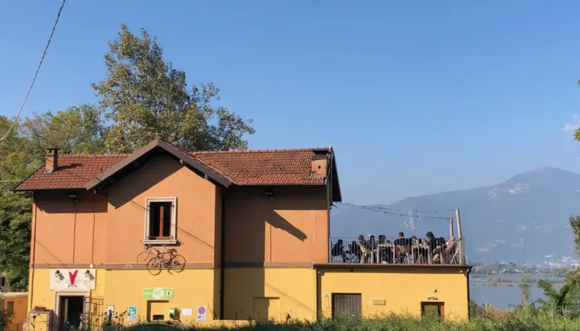 Un locale con tavoli all'aperto e vista sul lago d'Iseo, dove si respira l'atmosfera delle cantine locali.