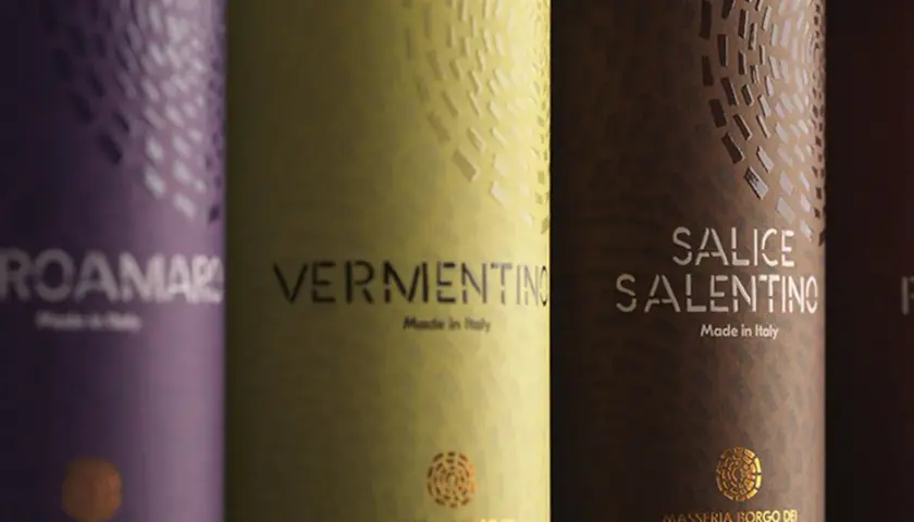Etichetta vino esempio: bottiglie di Negroamaro, Vermentino, Salice Salentino e Primitivo, con dettagli dorati e texture uniche.