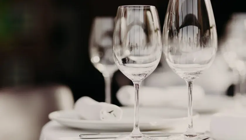 Due calici d'acqua e vino, pronti per una cena. Le differenze tra i calici sono sottili, ma importanti per l'esperienza.