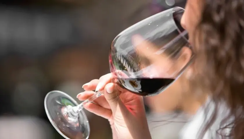 Donna assapora un vino amabile, con un sorso che promette piacere.