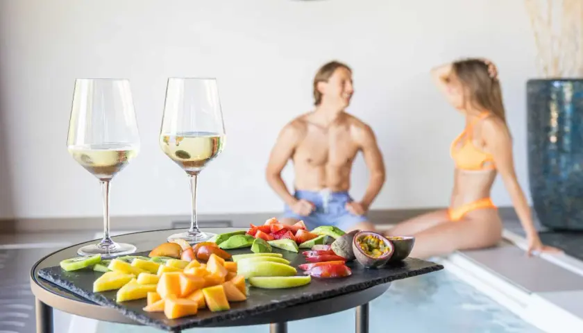 Coppia rilassata alle terme con degustazione di vino e frutta fresca. Un momento di puro piacere.