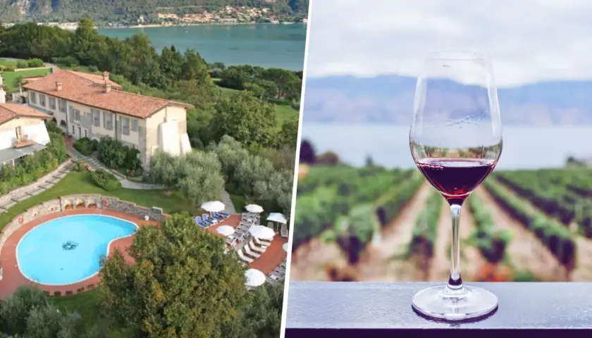 Un bicchiere di vino rosso con vigneti e lago sullo sfondo, ideale per una visita cantine Franciacorta con pernottamento.