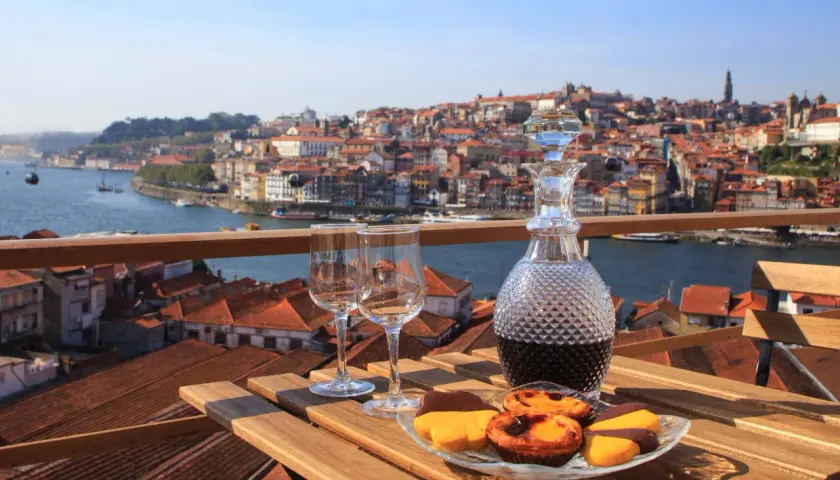 Un bicchiere di **douro vino** e dolci su un tavolo con vista su Porto.