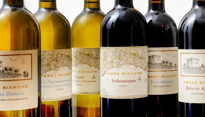 Bottiglie di vino Terre Bianche, con etichette che raffigurano mappe antiche e disegni di ville.