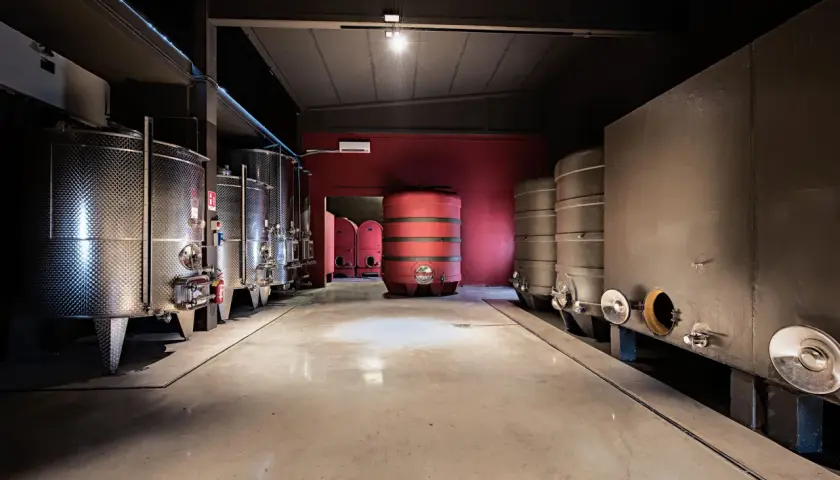 Cantine moderne con serbatoi in acciaio inox e botti, un ambiente pulito e funzionale per la produzione di vino, forse in un rinomato garetto.