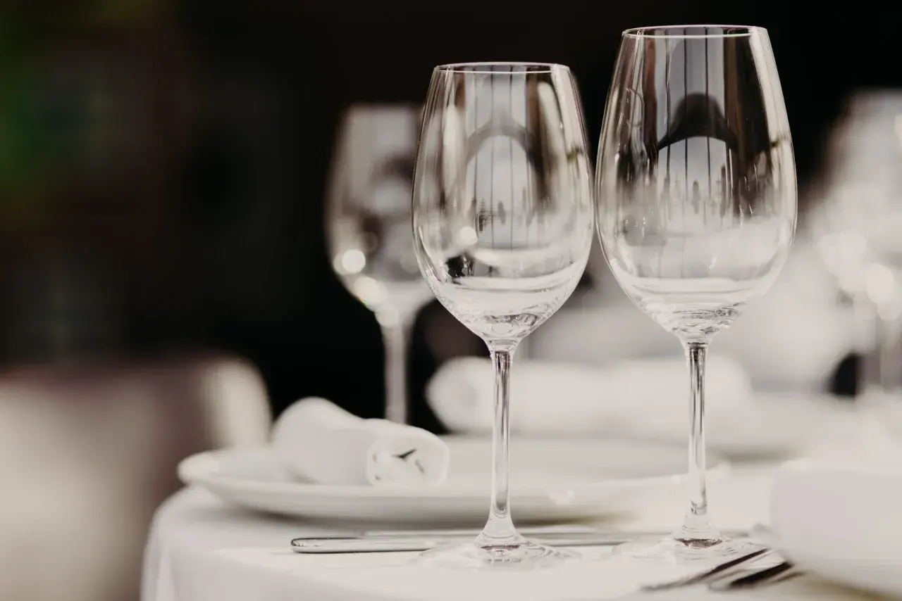 Due calici d'acqua e vino, pronti per una cena. Le differenze tra i calici sono sottili, ma importanti per l'esperienza.