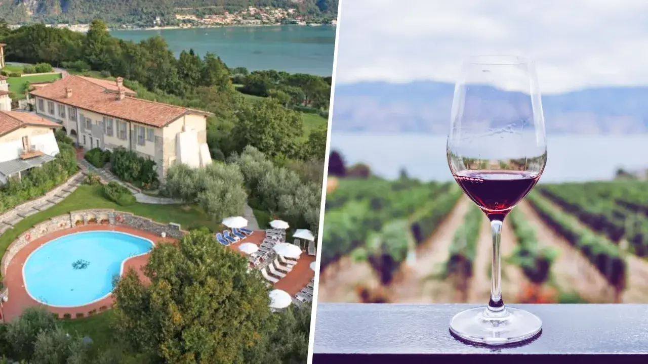 Un bicchiere di vino rosso con vigneti e lago sullo sfondo, ideale per una visita cantine Franciacorta con pernottamento.