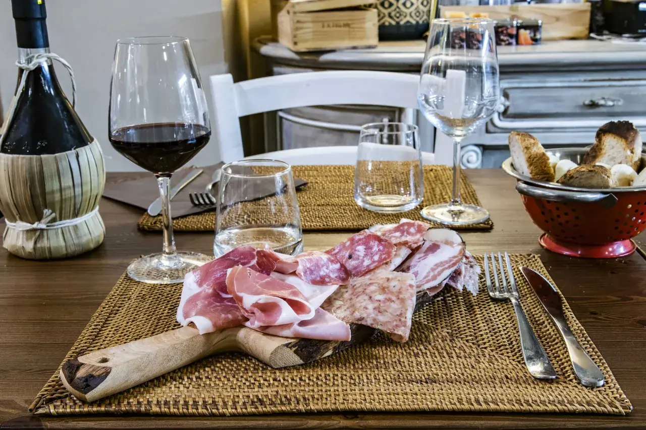 Tagliere di salumi e vino rosso, un assaggio delle cantine Greve in Chianti.