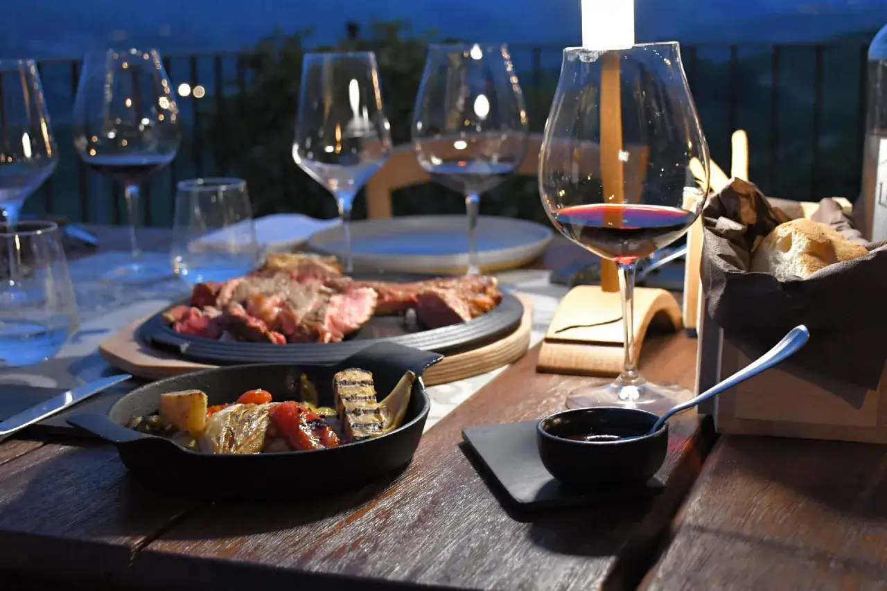 Un'esperienza culinaria indimenticabile: un tour enogastronomico nelle Langhe con bistecca, verdure grigliate e vino rosso.