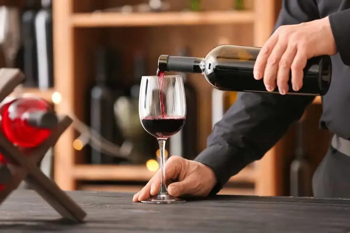 Versando vino rosso in un bicchiere, attenzione all'acidità volatile del vino.
