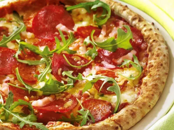 Pizza con salame piccante, rucola e formaggio filante. Un abbinamento classico e gustoso per un'esperienza culinaria indimenticabile.